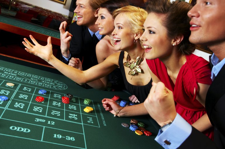 Люди играют на рулетке в казино